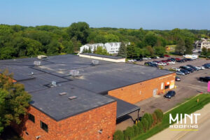 aerial photo of red brick commercial building with new black roof